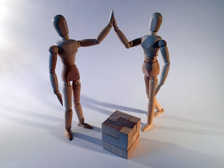 Dos figures articulades que xoquen la mà