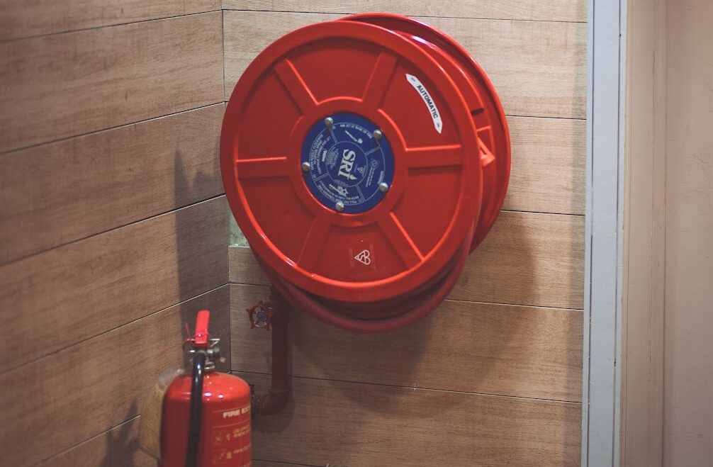 Extintor i mànega contra incendis en una sortida d'incendis d'un edifici.