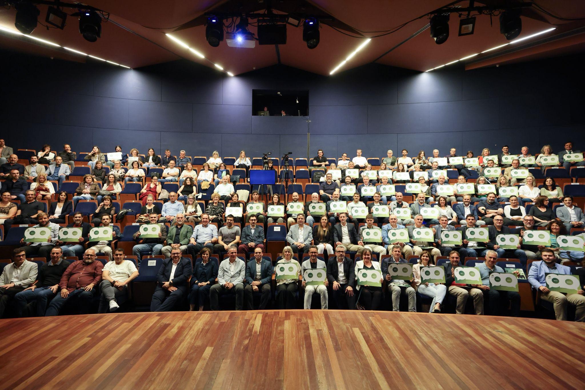 Ens guardonats asseguts a platea